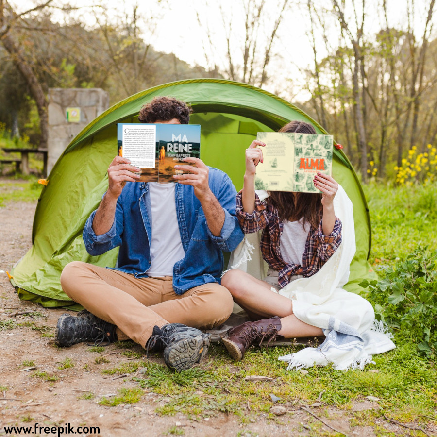 Un homme et une femme lisant devant leur tente