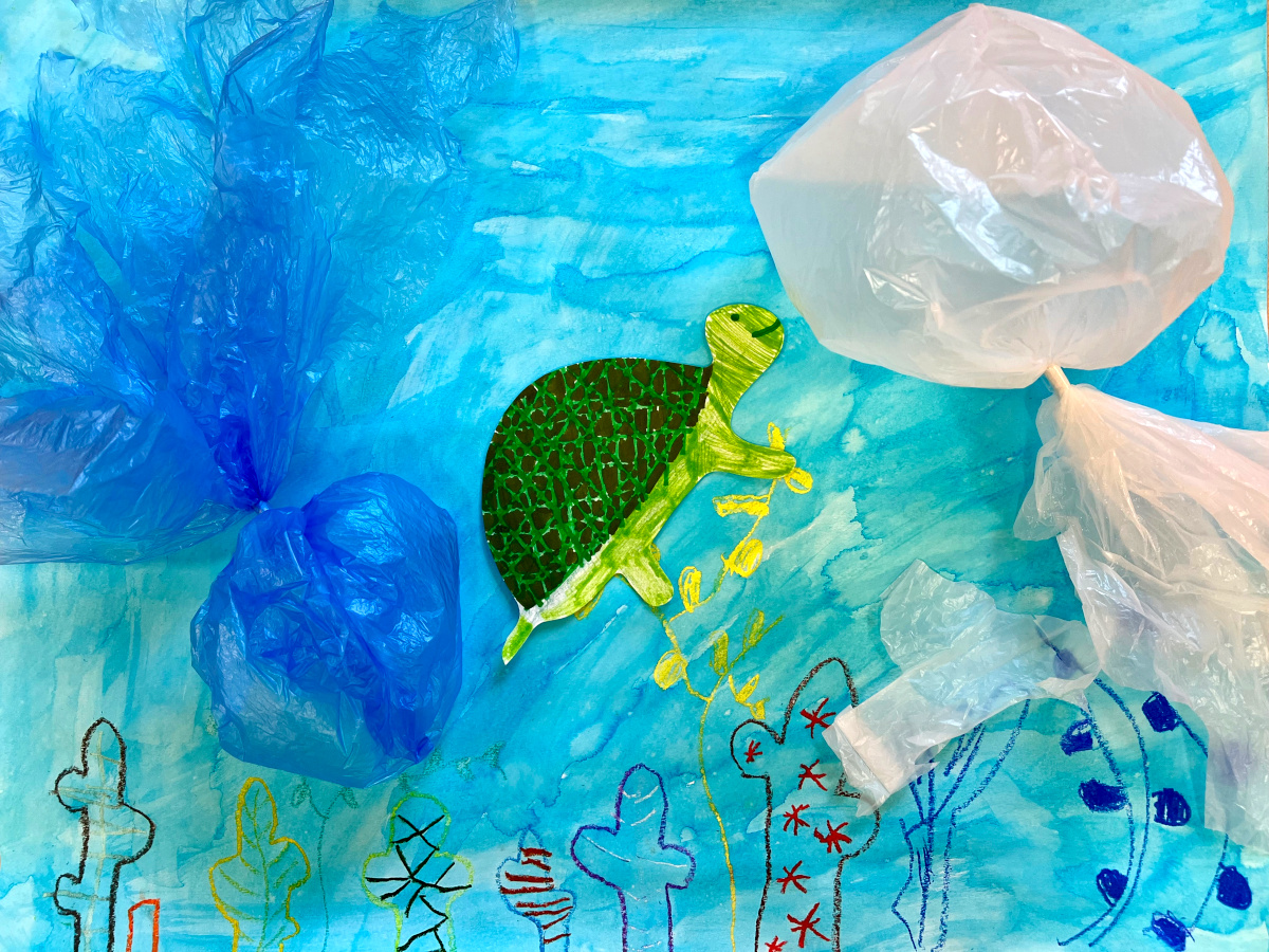 Tortue nageant dans l'océan entourée de sacs plastiques