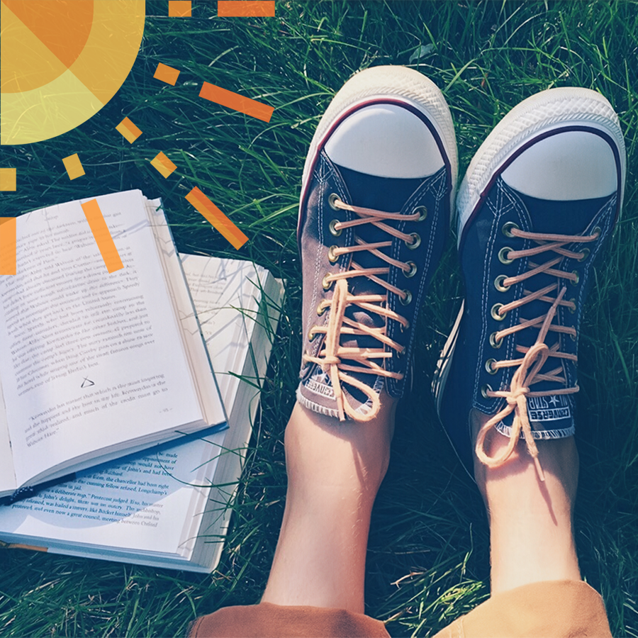 2 livres ouverts et vision de 2 pieds avec baskets dans l'herbe, soleil