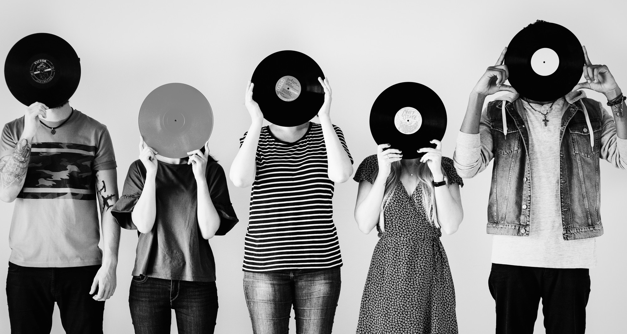 cinq personnes debout tête cachée derrière un vinyle